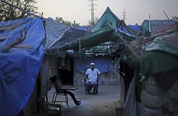A Rohingya refugee waits for customers at a camp for the refugees in New Delhi, India (Sept. 12, 2017).