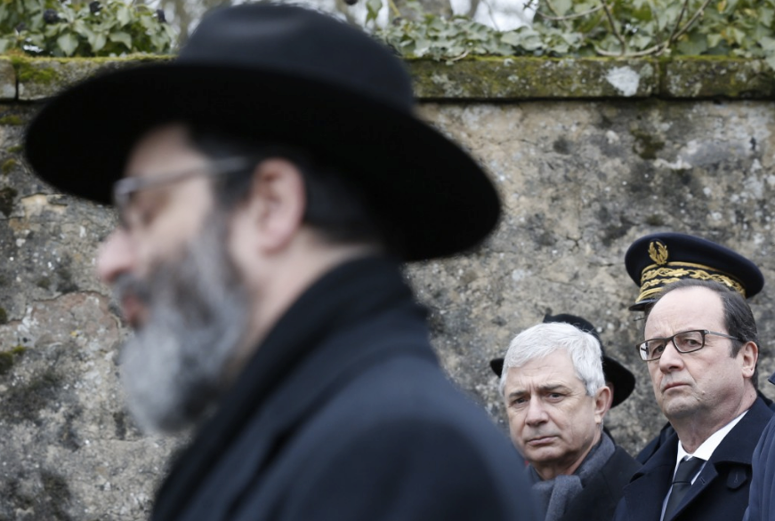 French President François Hollande, right, and French National Assembly Speaker Claude Bartolone, center, attend a ceremony during a visit to a Jewish cemetery in France last year. (Vincent Kessler/Pool/European Pressphoto Agency)