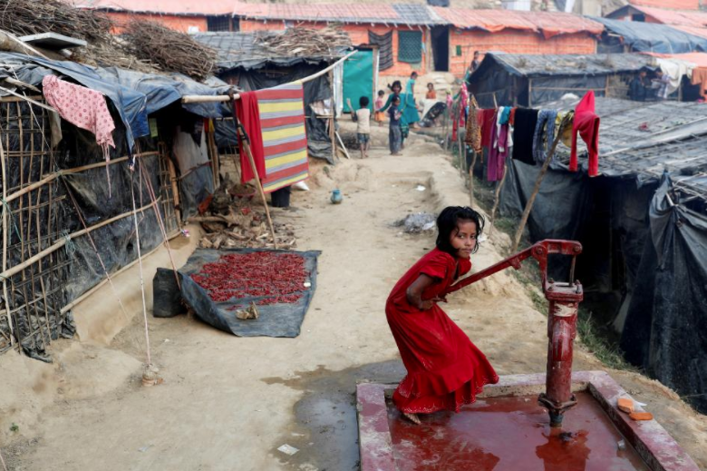 A Rohingya refugee girl plays at a tube-well in Palong Khali camp, near Cox's Bazar, Bangladesh January 14, 2018. REUTERS/Tyrone Siu