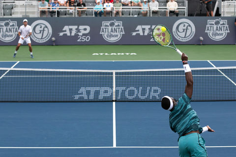 Francis Taifoe wears all blue while serving the ball to his competitor in Atlanta