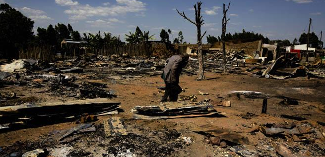 A man walks through ruins of an area of Chepilat in the Rift Valley Province, February 2008. The burning of homes by Kalenjin men, forced residents of both the Kisii and the Kikuyu ethnic groups to flee. © 2008 Marcus Bleasdale/VII
