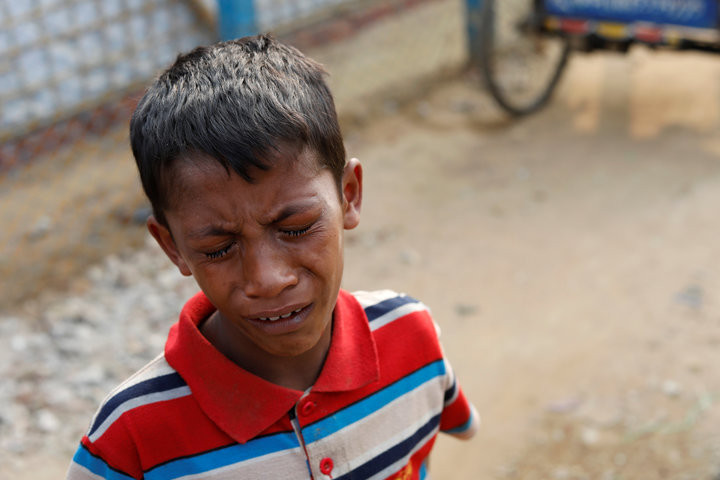 TYRONE SIU / REUTERS A young Rohingya boys cries outside a hospital in the Kutupalong refugee camp after learning his father was killed, Jan. 13, 2018.