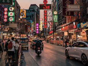 Yaowarat Road in Bangkoks Chinatown bei Nacht mit Leuchtreklamen, Verkehr und Fußgängern