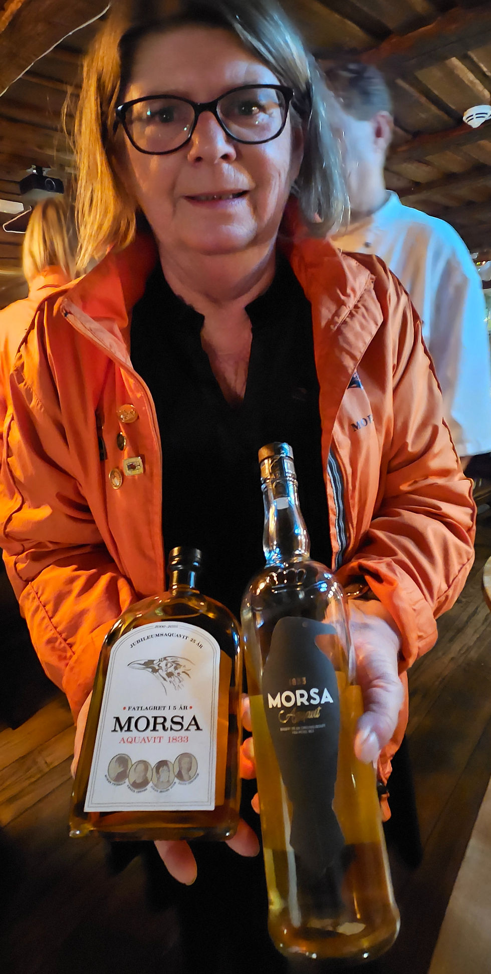 President Ellen Pongo viser frem både jubileums-akevitten og den vanlige Morsa-akevitten (til høyre), med splitter nytt design for anledningen produsert på Atlungstad Brenneri.