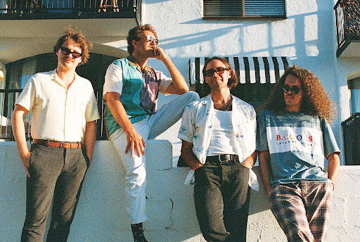 Band Caravana Sun leaning against a building
