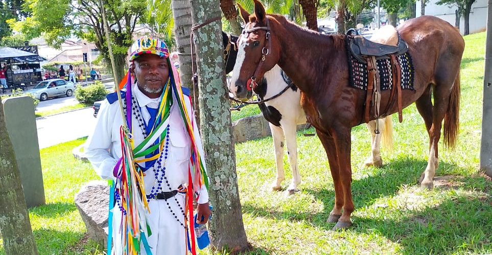 60- Mestre Caxeiro Marcelo Lourenço de Oliveira: Homem de pele negra usando uniforme branc