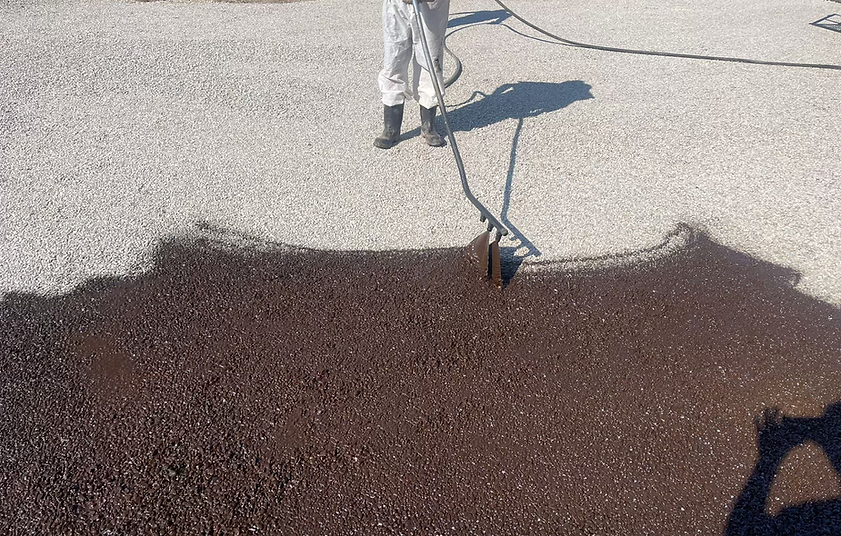 asphalt emulsion being laid on a driveway