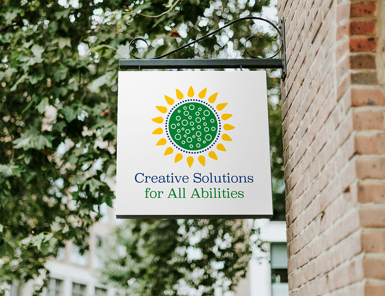 Creative Solutions for All Abilities on a sign outside attached to a brick building