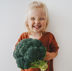 Child girl with broccoli healthy food vegan eating lifestyle organic vegetables plant base