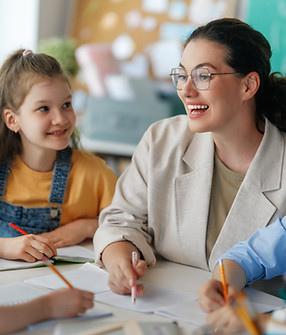 Happy kids and teacher at school. Woman and children are working in the class..jpg