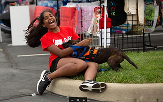 OPC volunteer plays with a local dog at community event