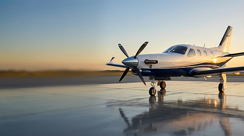 Propeller plane on wet tarmac, sunset reflection