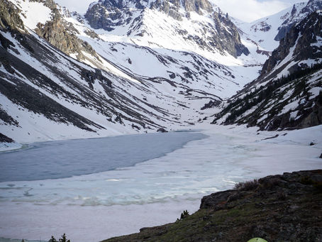 Snow-covered Spirit mountain, overlooking Black Canyon Lake and rocky slopes, on a climbing trip with Beartooth Mountain Guides