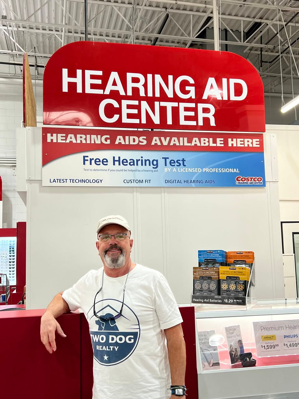 Curt Reichstetter in a Two Dog Realty shirt at a hearing aid center