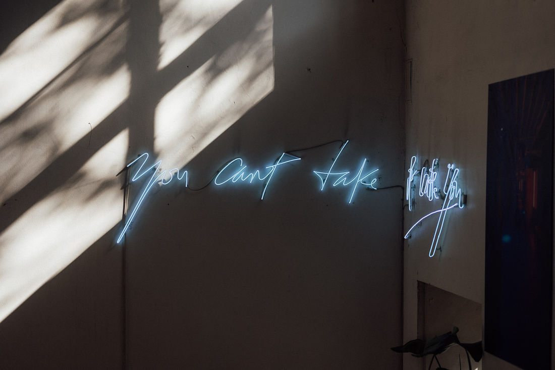 Neon‑Schriftzug an einer dunklen Wand in der Alten Münze Berlin.