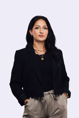 Businessportrait einer Frau in schwarzem Blazer mit beiger Hose.