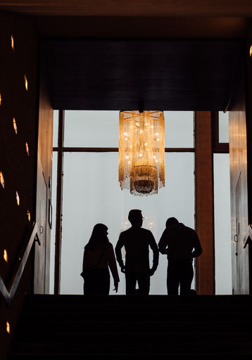 Silhouetten von Personen in einem dunklen Kinoflur.