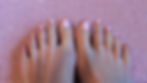 Close-up of a woman's feet on a pink carpet, toes painted in a cheerful pink, symbolizing the pleasure found in the simple, personal moments of care and expression.