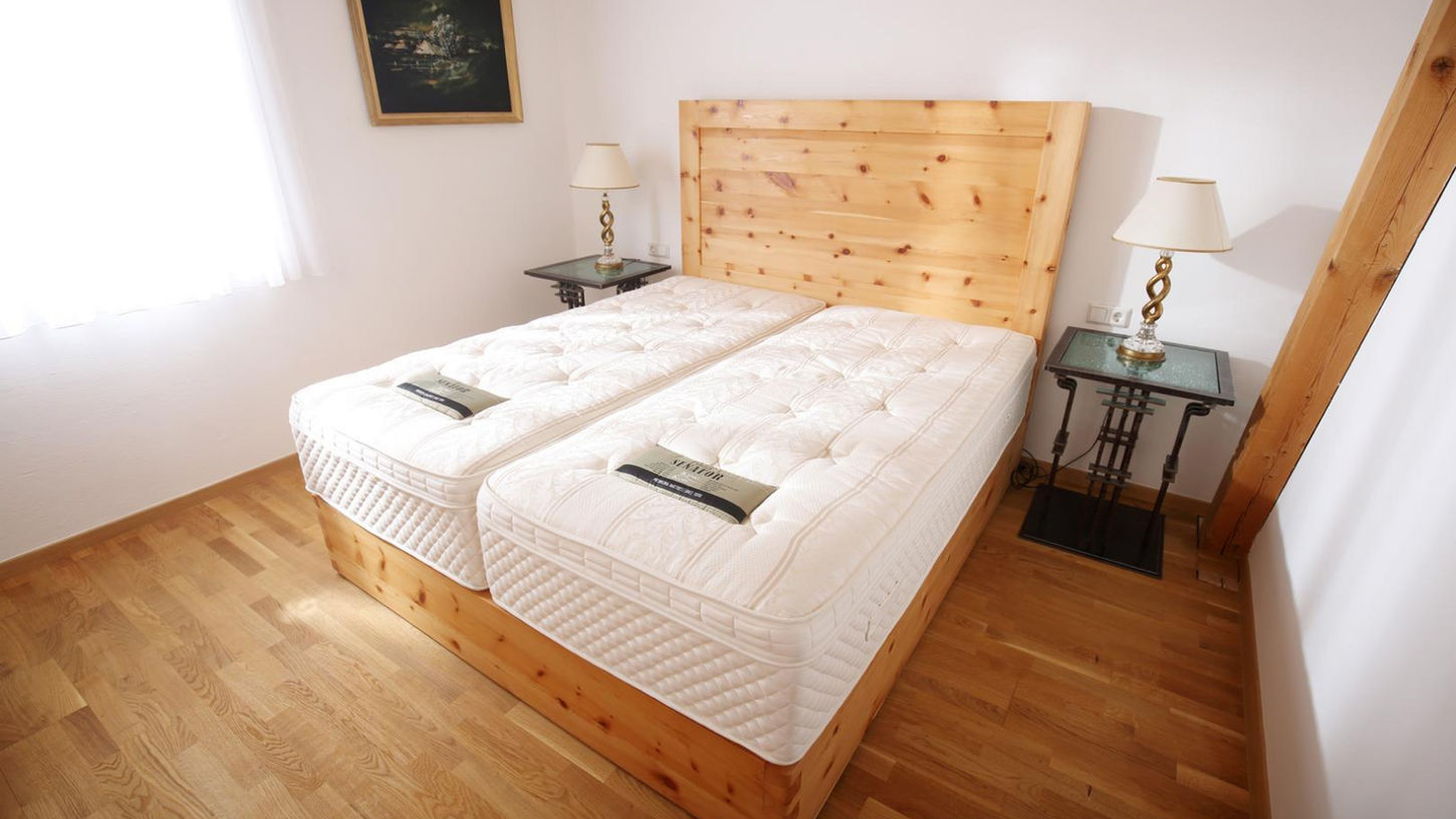 Zirbenholz Boxspringbett nach Maß mit massivem Kopfteil und hoher Einstiegshöhe