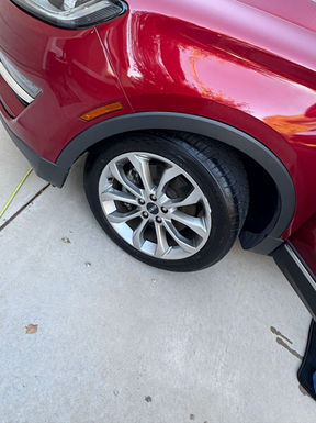 Red car wheel and tire close up view on concrete ground