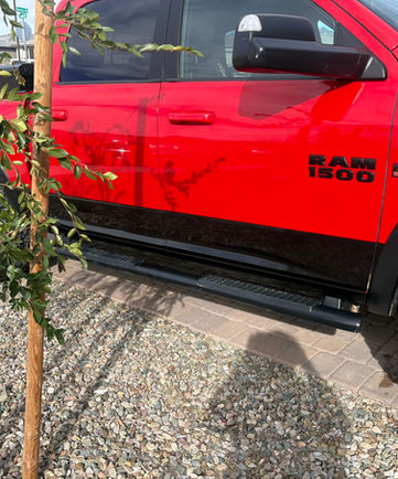 Red Ram 1500 truck detail with black accents parked on the street.