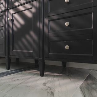 Close-up of black vanity drawers and marble flooring