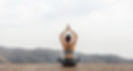 Woman sitting in front of a mountain in a relaxed yoga position