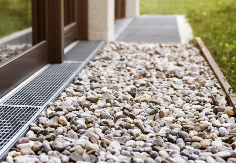 Completed installation of a MEA stainless steel drainage system running along the landscaped garden pathway