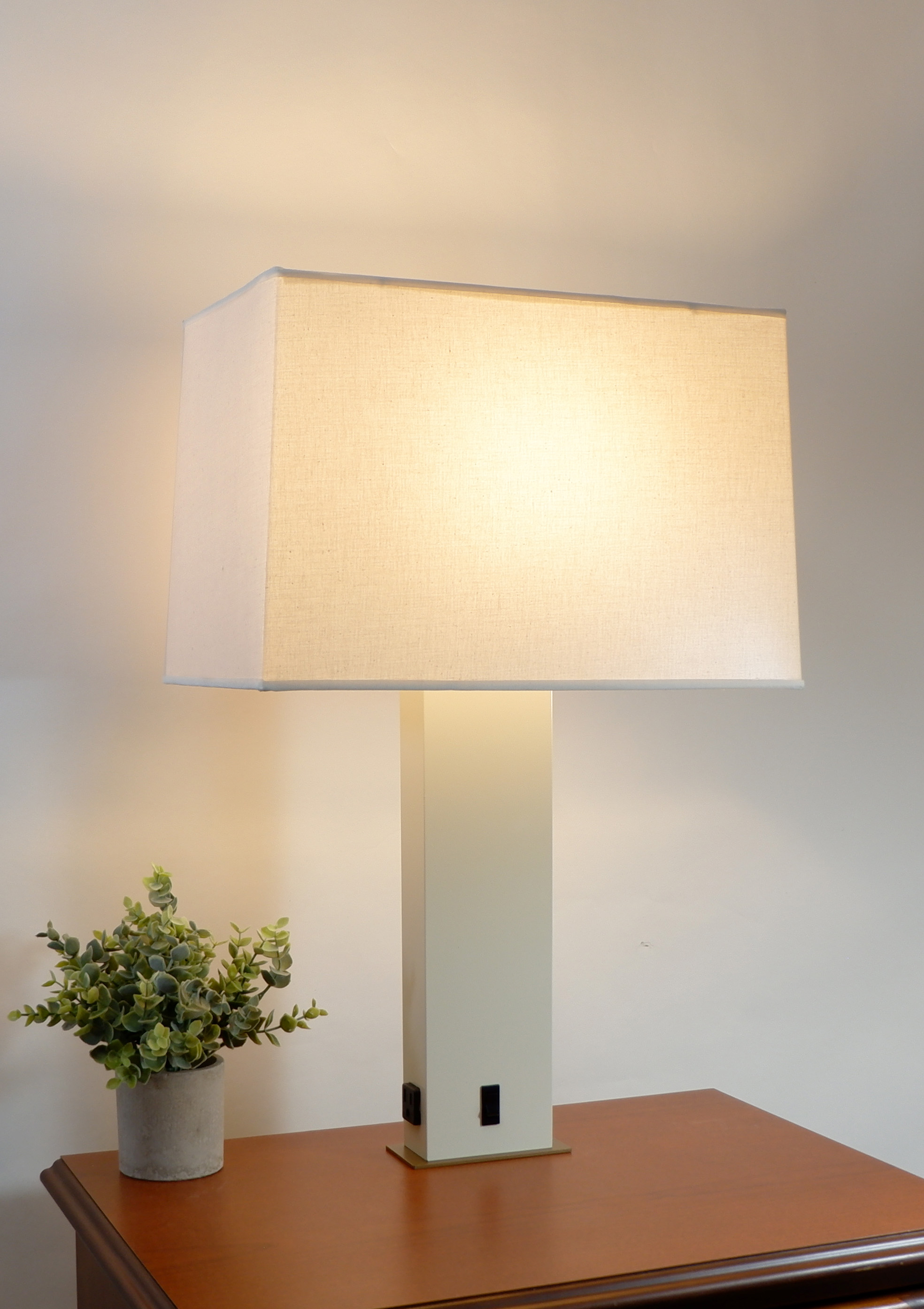 JES Lighting lamp on a bedside table, warmly illuminating a room