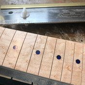 Fret markers and bird's eyes Inserting fret markersLocating the fret markers -  the image shows a partially completed Malone Guitars electric guitar neck. The neck is made from birds eye maple. Pencil marks show the centres of the fret dots. The fret markers are made from transparent blue acrylic