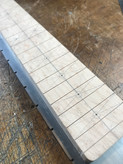 Locating the fret markers -  the image shows a partially completed Malone Guitars electric guitar neck. The neck is made from birds eye maple. Pencil marks show the centres of the fret dots