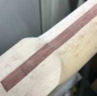 Carving the heel Inserting fret markersLocating the fret markers -  the image shows a partially completed Malone Guitars electric guitar neck. The neck is made from birds eye maple with a bubinga skunk stripe