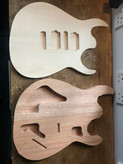 Top and back - a partially complete guitar body - the mahogany back lays next to the flamed maple cap