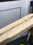 Carving the neck - a partially carved Malone Guitars birds eye maple guitar neck. The neck is dusted with wood dust