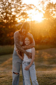 Mom hugging daughter in front of golden hour sunset in Williamsport PA family session