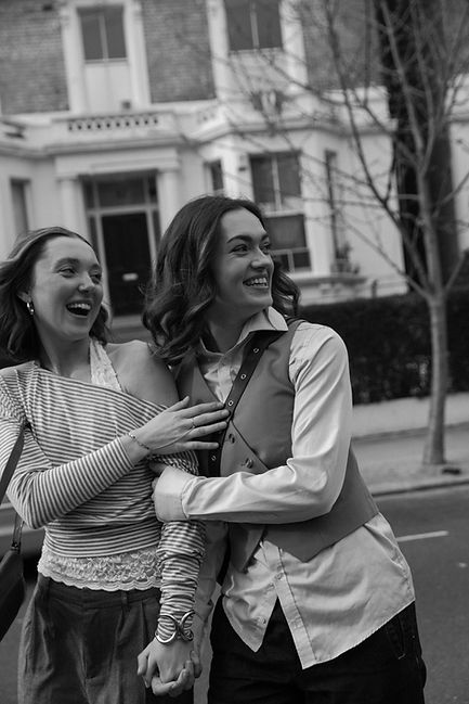 Black and white photo of couple laughing on historic street in Notting Hill, London