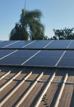 Painéis solares instalados em telhado metálico residencial.