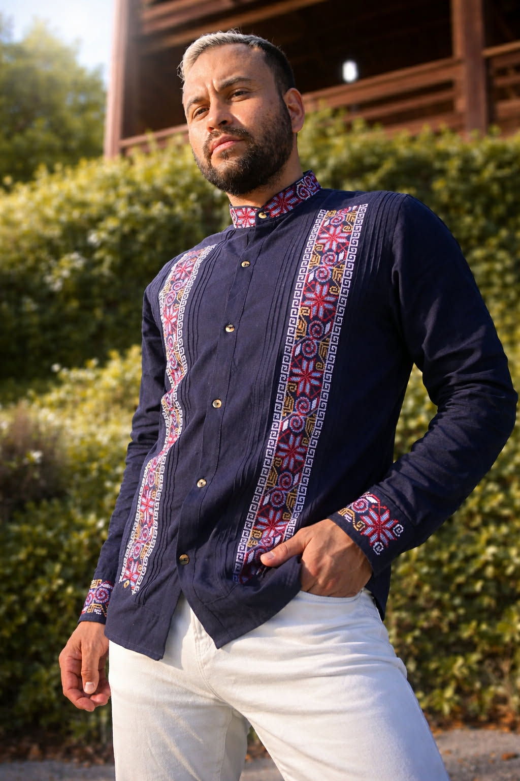 Man in a dark blue shirt with pink floral embroidery