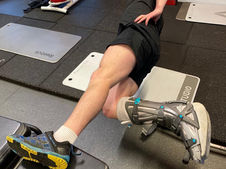 Individual in leg cast performing a modified side plank in the gym