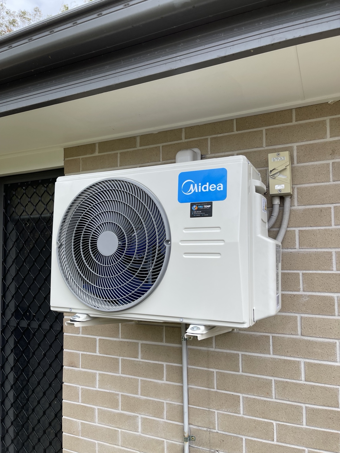 Clean Midea outdoor installation on wall brackets