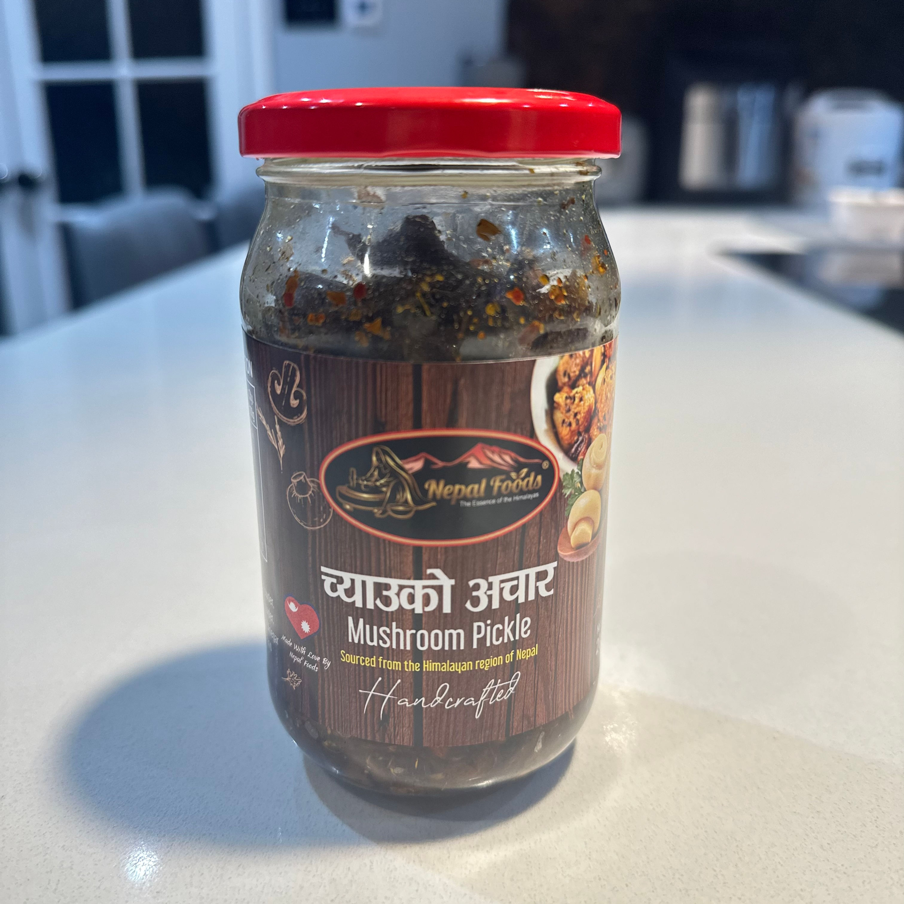 Jar of Mushroom Pickle, with text in Nepali, and Pasupati papad. Your Kathmandu