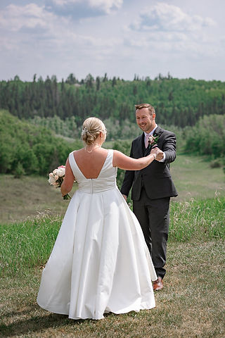 groom smiles at bride during first look
