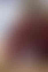 bride and groom hold hands and smile at each other infront of barn