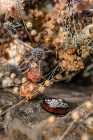 Wedding rings nestled among natural rocks and foliage on their Crowsnest Pass wedding day