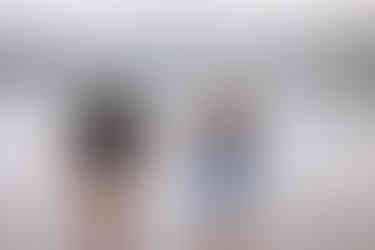 Couple laughing and holding hands while running through the water during fun engagement photos captured by a Waterton Park wedding photographer.