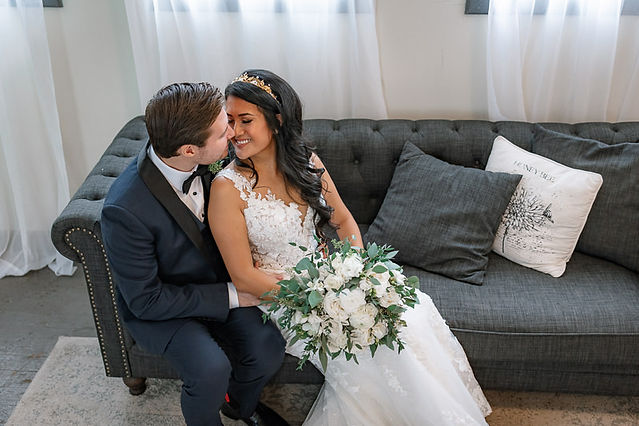 Birds eye view photo of couple sitting on couch and smiling at one another 