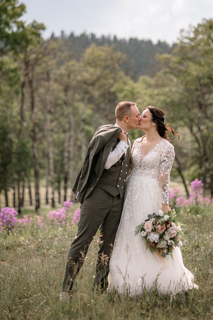 Groom kissing his bride in the forest