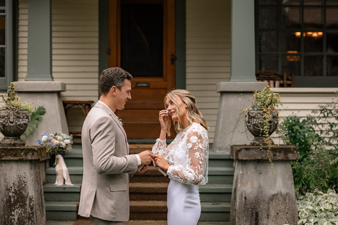Bride wiping her eyes and holding hands with the groom after reading her vows during a pre-ceremony moment at their Bragg Creek wedding