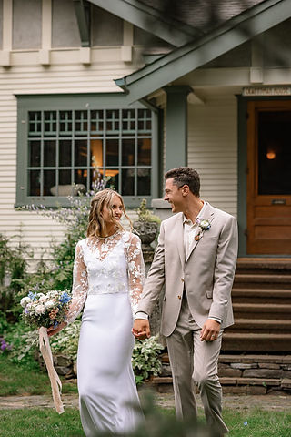 Bride and groom walking hand in hand outside, smiling at one another at one of the Bragg Creek wedding venues