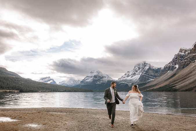 UK couple running hand in hand in Banff national park on their elopement day
